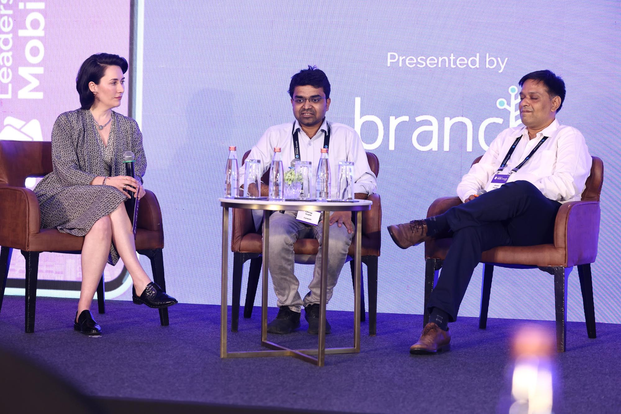 Chirag Gupta, Ameet Phadke, and Stephanie Herndon-Rasse are each seated on stage in front of a round table.