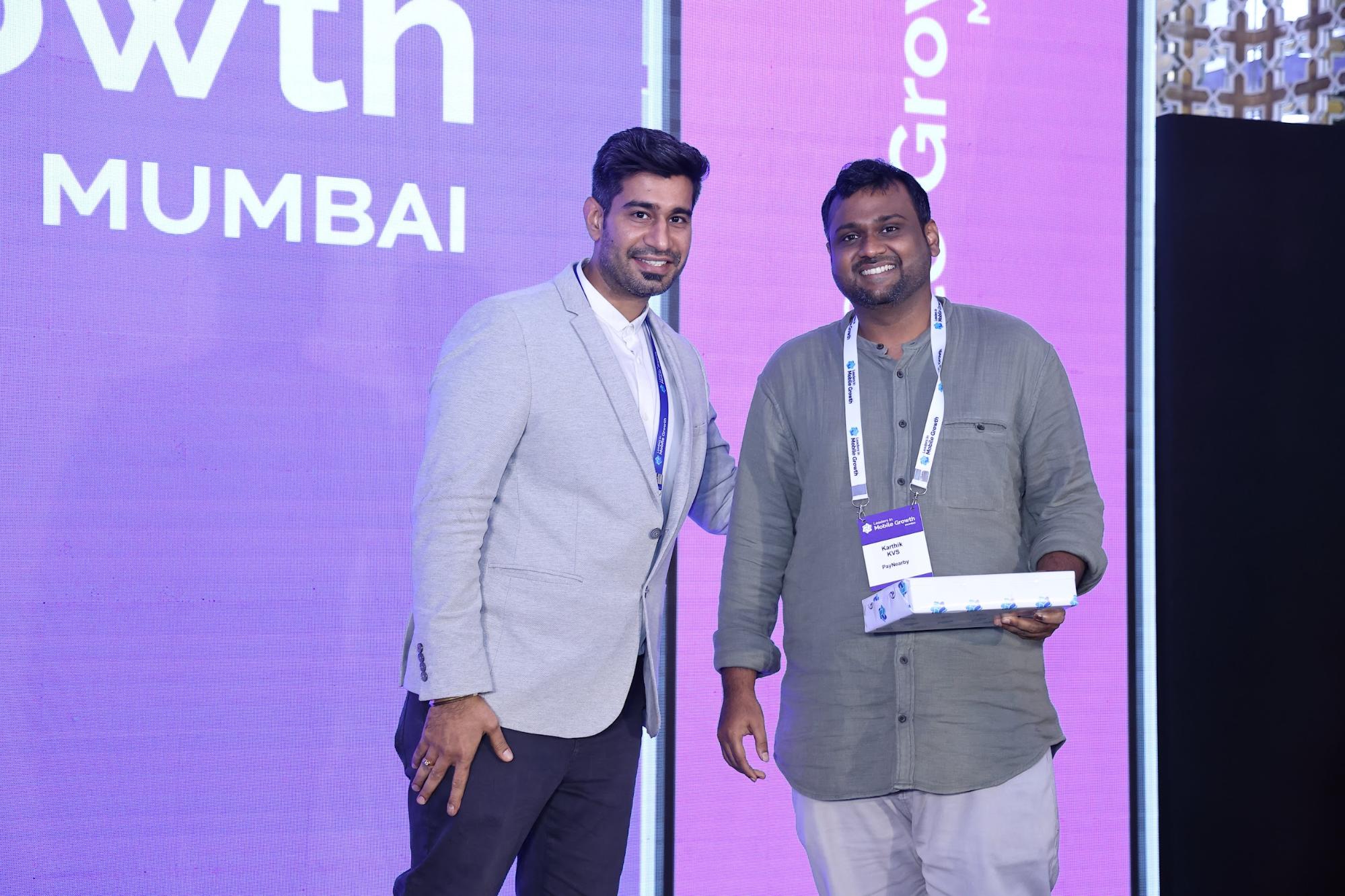 Karthik KVS poses on stage accepting his iPad.