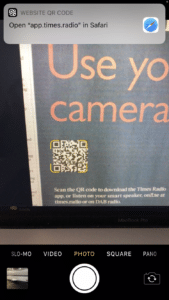 QR code being scanned from a newspaper